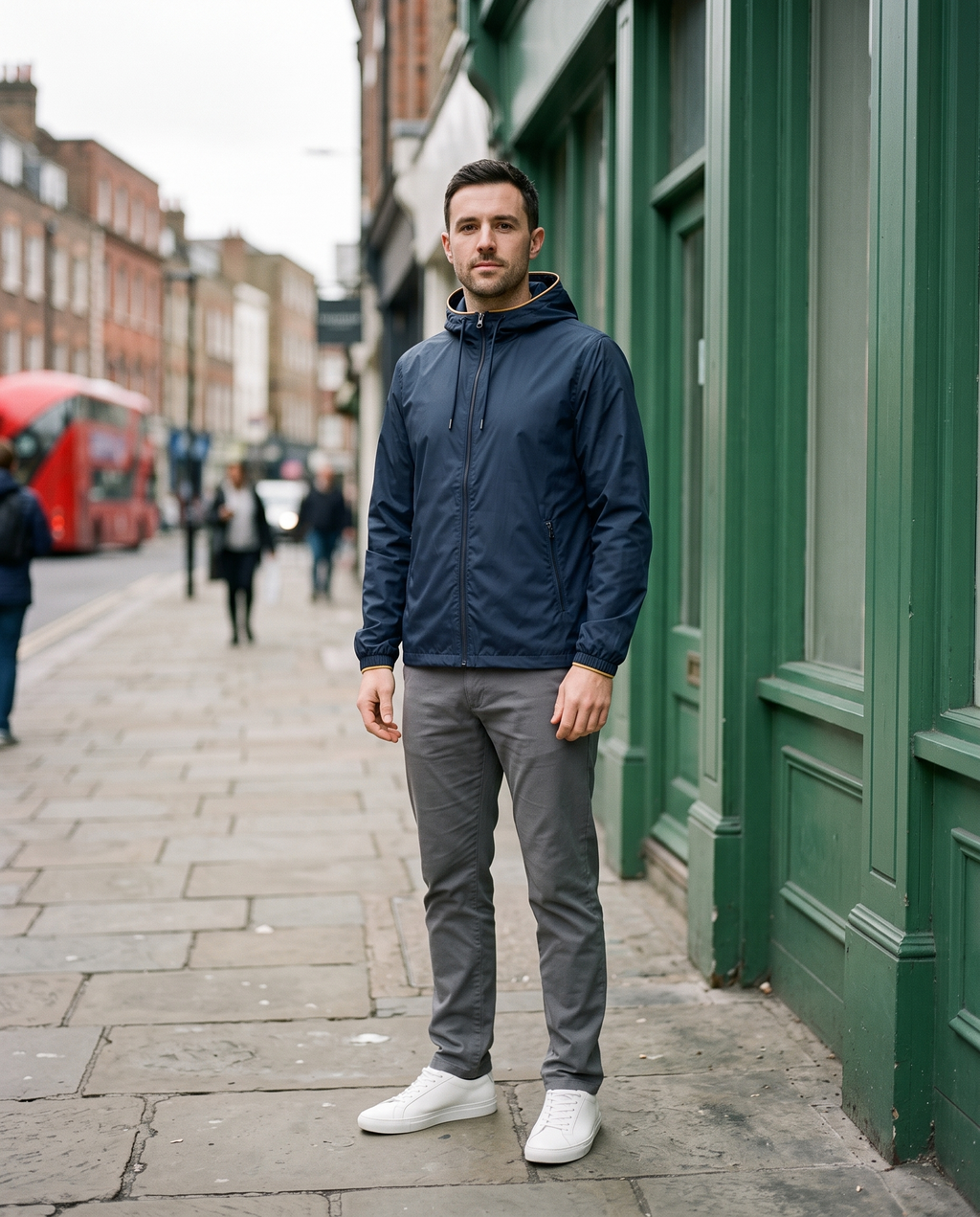 Man wearing navy windbreaker on a city street