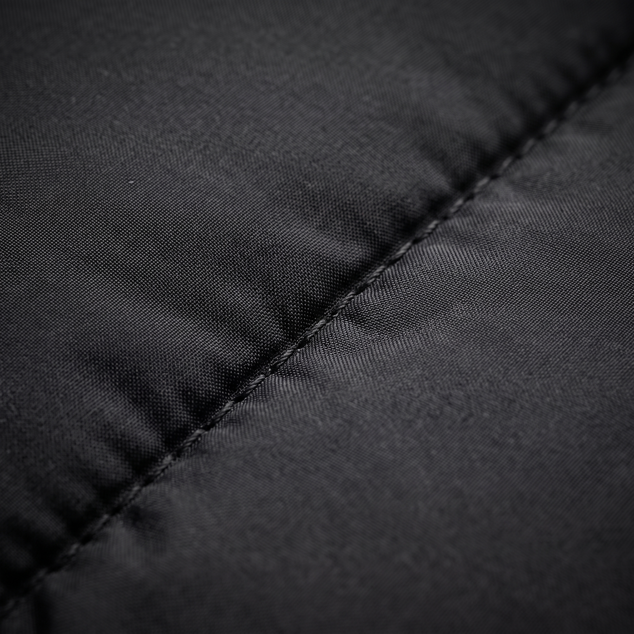 Black puffer jacket quilted nylon fabric macro
