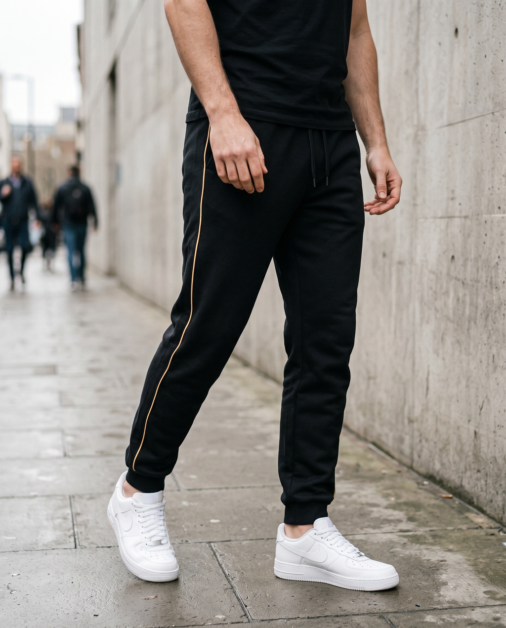 Man wearing black tapered track pants on a city street