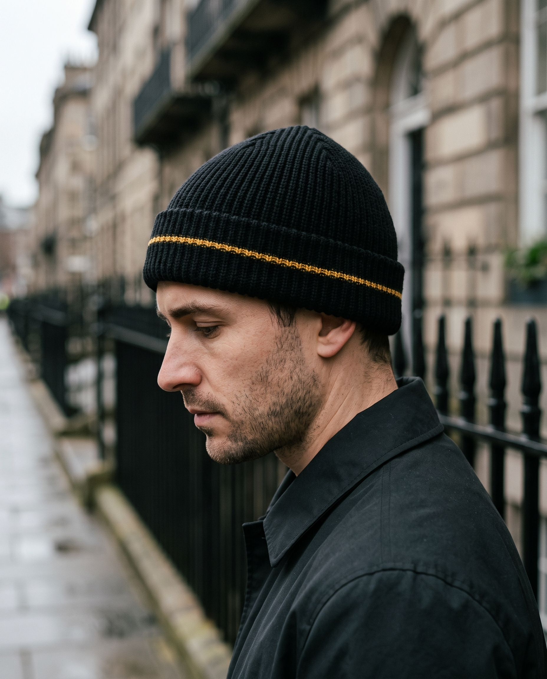 Side profile of man wearing black ribbed beanie