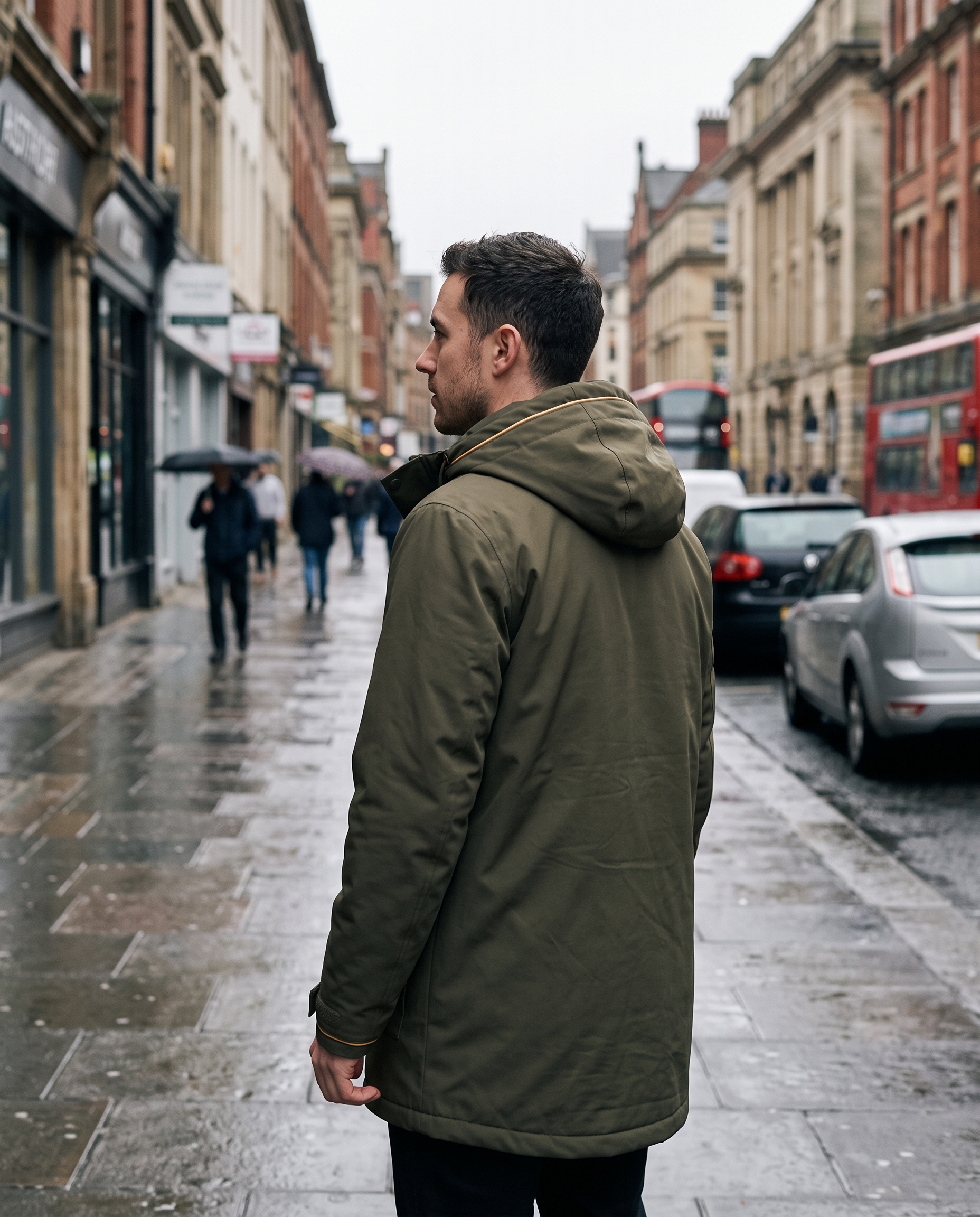 Man in olive green parka with hood up, seen from behind